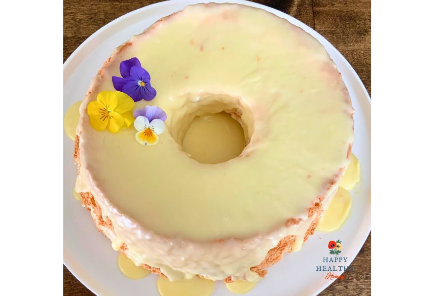 Gluten-free angel food cake with glaze and edible flowers, showing how to fix a fallen cake