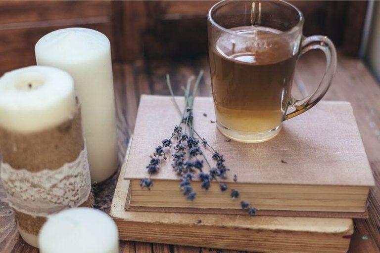 Cozy tea, candles, and books representing rest and slow living after illness