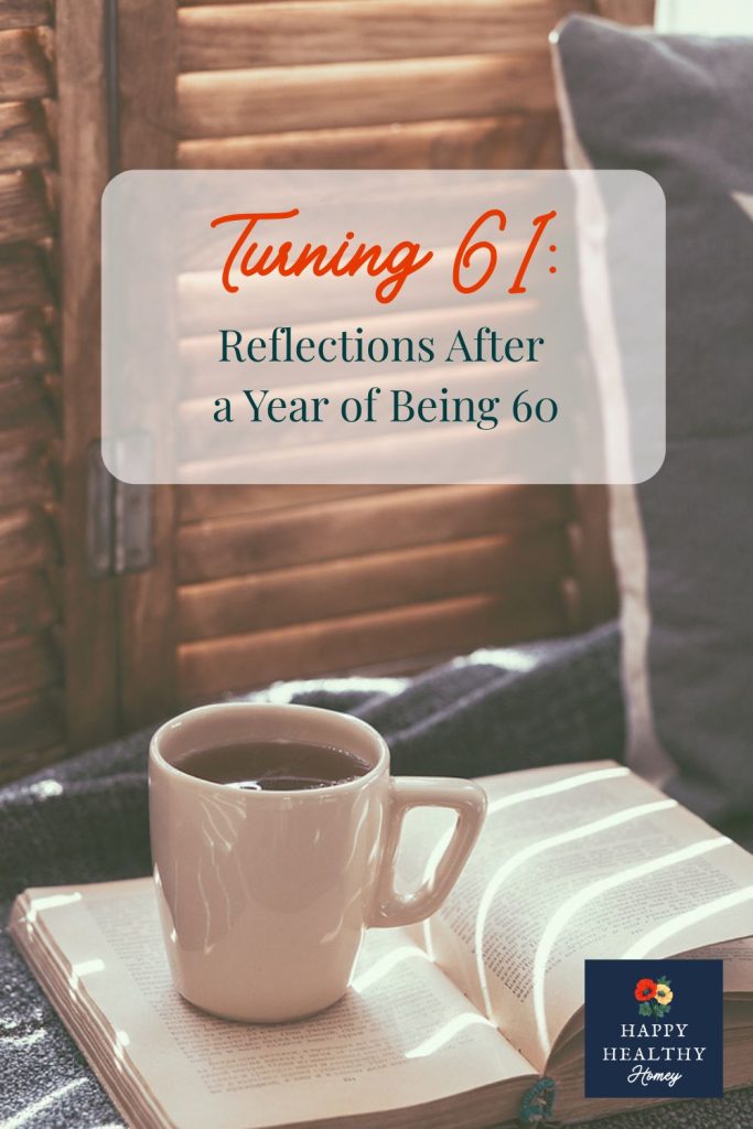 Cup of coffee beside an open book on a cozy table with text overlay about turning 61 and reflections after a year of being 60.