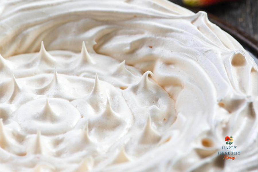 Closeup of a gluten-free meringue pie shell with golden peaks.